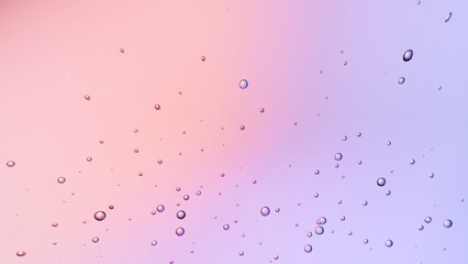 Droplets hover gracefully against a pastel pink and purple gradient background, creating a tranquil and serene ambiance typical of a peaceful morning setting. 3d render