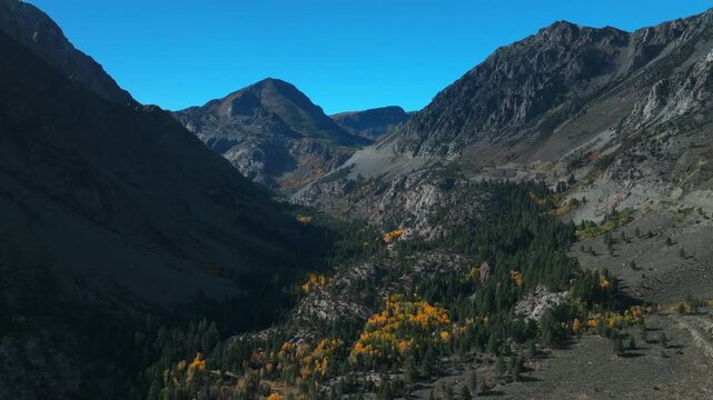 West Portal Entrance rugged Mountains Lee Vining Tioga Pass Road Yosemite National Park California aerial drone Ansel Adams Wilderness autumn fall yellow orange Aspen Trees blue skies circle right