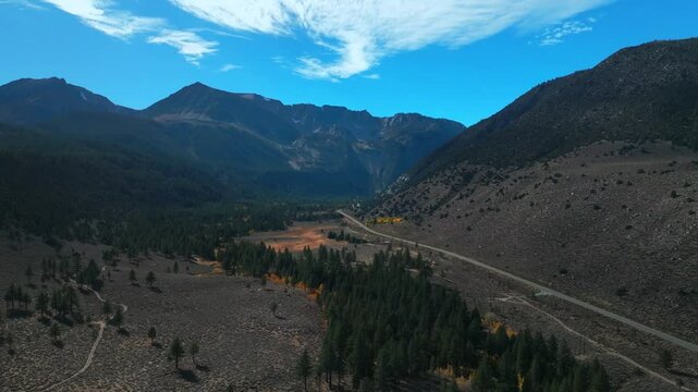 West Portal Entrance Mountains Lee Vining Tioga Pass Road Yosemite National Park California aerial drone Ansel Adams Wilderness Big Oak Flat fall yellow orange Aspen Trees blue skies circle right