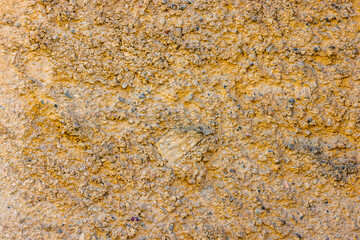 rugged beige concrete wall texture with pebbles