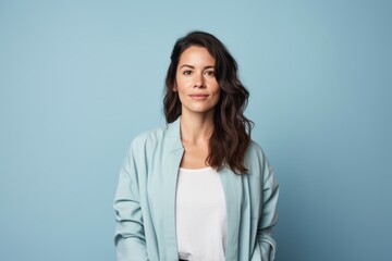 Fototapeta premium A woman in a blue jacket and white shirt is smiling for the camera