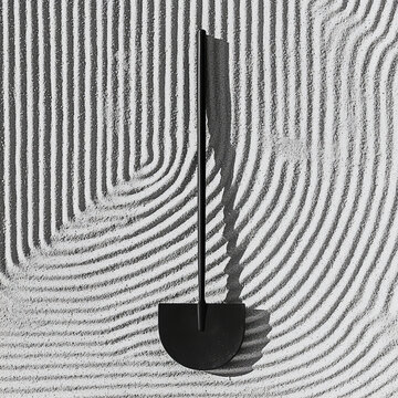 Black garden tool on raked sand