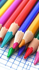 Naklejka premium Colorful pencils on graph paper; back to school supplies