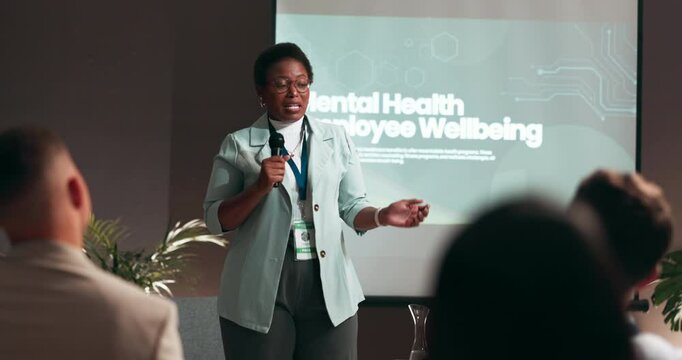 Business woman, presentation and screen with mic for group seminar, conference or convention at office. Female person, speaker or speech with staff for mental health training or wellbeing at workshop