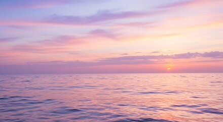 Obraz premium A dreamy pastel sunset over a calm ocean with soft waves and glowing clouds