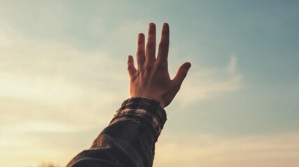 Hand Reaches Sky at Sunset