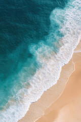 A breathtaking aerial view of the turquoise ocean waves gently rolling onto a pristine sandy beach.
