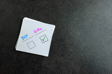 Baby boy or girl handwritten on notepad. Baby shower, concept will be boy or girl