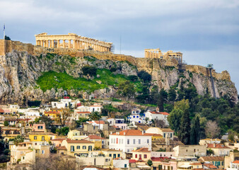Naklejka premium View of the Acropolis and Athens with traditional houses under a cloudy sky
