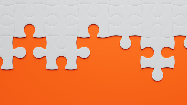 Striking Contrast: Partially Completed White Jigsaw Puzzle on Vibrant Orange Background