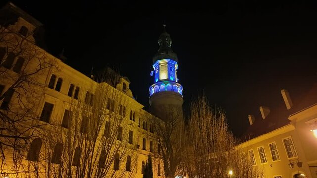 The Fire Tower in Sopron illuminated with vibrant light colors at night, creating a stunning light show.