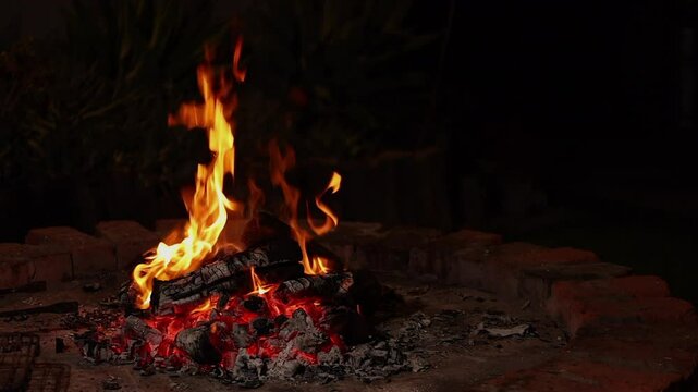 Night bonfire in brick firepit in South African boma on dark night