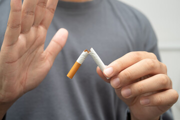 Quit smoking, Asian teenage man breaking destroy cigarette in hand.