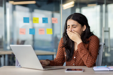 Boring monotonous everyday work. Woman at workplace sleepless yawning sitting at desk with laptop...