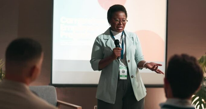 Conference, audience or businesswoman with mic for speech, training or workshop for employees health. Crowd, presenter or program with talking for seminar, presentation or workplace wellness on stage