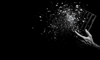 Obraz premium Hand Shattering Objects in Darkness Creating a Dramatic Visual Effect