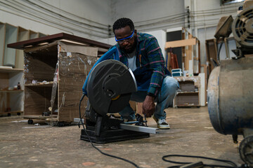 Afro american craftsman working as carpenter in a carpentry workshop