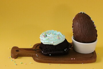 Easter holiday, chocolate eggs and delicate cupcakes with blue icing