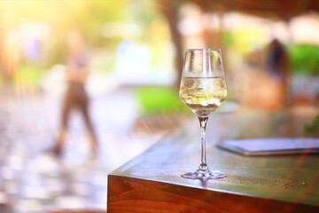 a glass of white wine served in a restaurant, abstract background of a summer restaurant