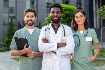 Group of young doctors in a clinic yard discussing patient case and looking interested