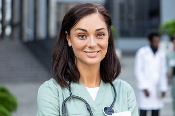 Waist up of a smiling female dark-haired doctor