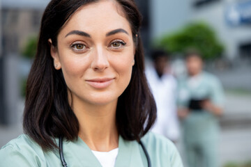 Fototapeta premium Waist up of a smiling female dark-haired doctor