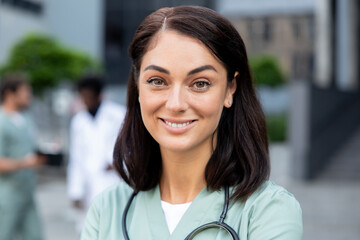 Obraz premium Waist up of a smiling female dark-haired doctor