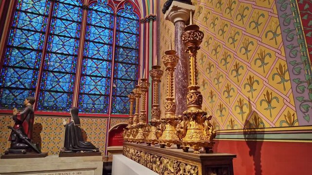 Ornate altar with golden decorations details inside the historic Notre Dame cathedral before stained-glass windows, Paris, France.