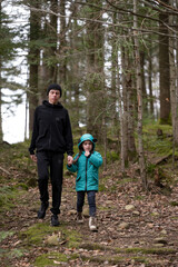 Embarking on an autumn adventure through the forest with nature's vibrant hues surrounding a parent and child enjoying quality time together