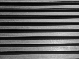 Wooden slatted panel with deep shadows and warm tones