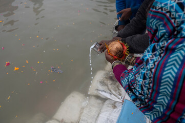  10 January 2025 In the early morning fog a Hindu devotee offers milk as a Prayer in the Ganges...