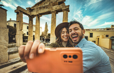 Happy couple of tourist taking selfie picture in front of old ancient in city street - Boyfriend...