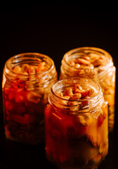 Jars filled with colorful fruits and nuts captured in warm lighting, showcasing homemade preserves at an evening kitchen setting