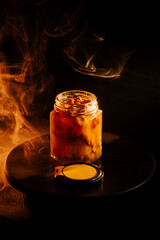 Honey infusion jar illuminated by warm lighting creates an inviting ambiance in a dark space