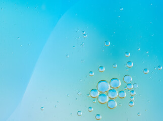 Transparent water bubbles rising in a light blue liquid background. Refreshing, clean photo perfect for themes of purity, hydration, freshness. Macro of hyaluronic acid, facial moisturizer.