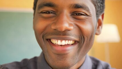 Portrait of smiling male African American teacher in a class at school looking at camera. This smiling teacher brings enthusiasm to the classroom, inspiring young minds daily.