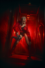 A beautiful woman secret agent in cyberpunk style with weapons in her hands on the background of an abandoned factory.