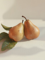 Two ripe pears with leaves, elegantly displayed against a soft background.