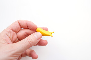 close up of a hand holding Handmade bird figurine body crafted from modeling clay, on white background. Unique DIY project, step in creative process,