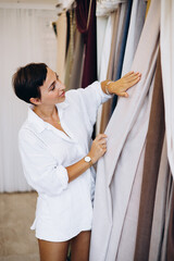 Woman choosing curtains and textile in a store