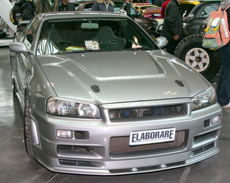 Rimini, Italy : 2019 03 29 Rimini Tuning free auto meeting A silver Nissan Skyline GT-R R34 on display at a car show, showcasing its iconic design and modifications.