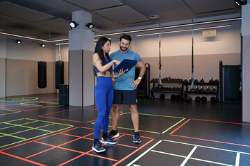 Fitness trainers discussing workout plans in gym