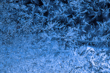 Frosty blue texture on window glass creating an abstract winter background with copy space