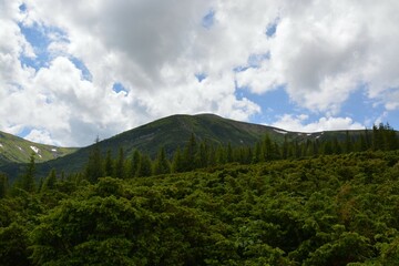 Mountain landscape with green hills and cloudy sky