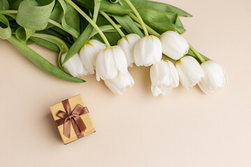 White tulips and a small gift box create a charming springtime arrangement. Copy space