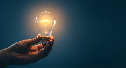 Hand holding glowing light bulb against dark background. Innovation concept, creative idea symbol. Inspiration and problem-solving visualization. Energy efficiency metaphor.