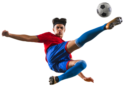 Portrait of young football player kicking ball in jump. Sportsman wearing red and blue uniform against transparent background. Concept of championship, action, team sport game, energy, vitality.