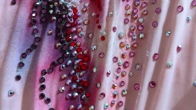 Rhinestones on the pink fabric, background. Sew clothes.