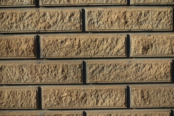 Close view of sand brown split face brick veneer wall with stretcher bond