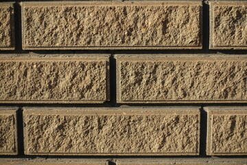 Macro of sand brown split face brick veneer wall with stretcher bond